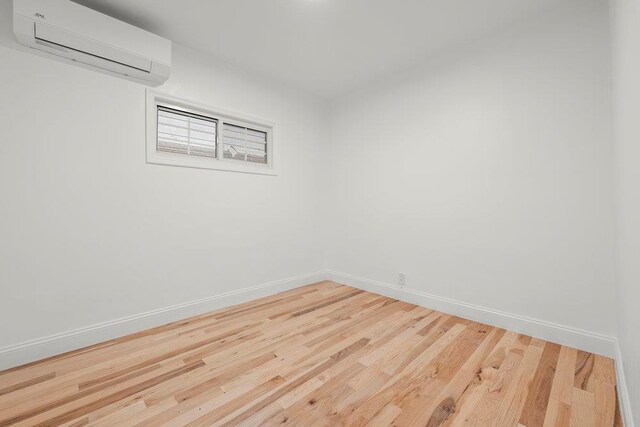 166-03 69th Ave, Fresh Meadows, NY 11366 - unfurnished room with a wall mounted AC, baseboards, and wood finished floors