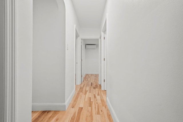 166-03 69th Ave, Fresh Meadows, NY 11366 - corridor featuring a wall mounted AC, light wood-style floors, arched walkways, and baseboards