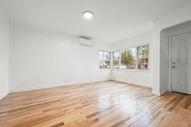 166-03 69th Ave, Fresh Meadows, NY 11366 - spare room featuring an AC wall unit, light wood-type flooring, and baseboards
