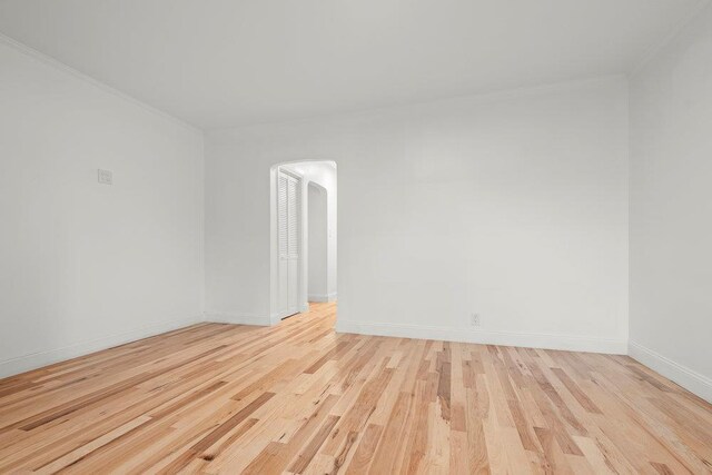 166-03 69th Ave, Fresh Meadows, NY 11366 - unfurnished room with arched walkways, light wood-style floors, and baseboards