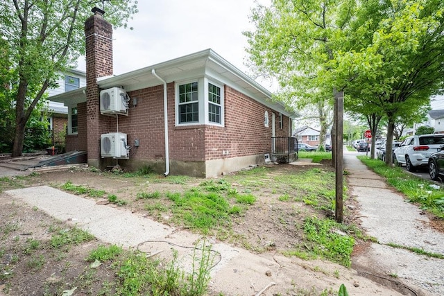 166-03 69th Ave, Fresh Meadows, NY 11366 - view of side of home featuring a chimney, brick siding, and ac unit