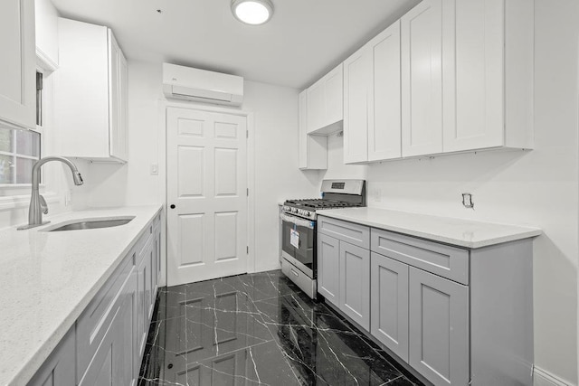 166-03 69th Ave, Fresh Meadows, NY 11366 - kitchen featuring gas range, a sink, a wall mounted AC, dark marble finish flooring, and light stone countertops