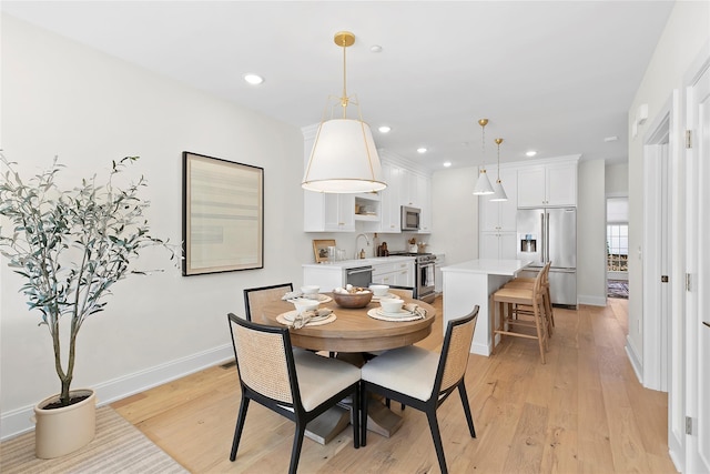 dining area with baseboards, recessed lighting, and light wood-style flooring