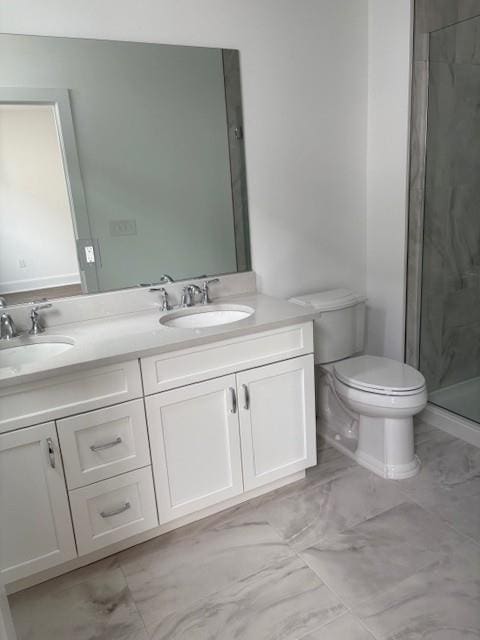 full bath featuring marble finish floors, toilet, a stall shower, and double vanity