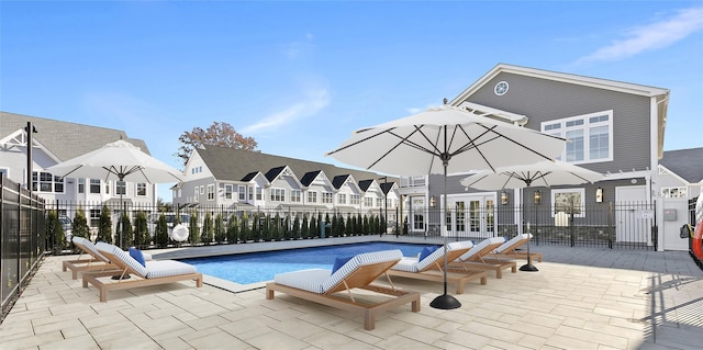 view of swimming pool with a residential view, fence, and a patio area