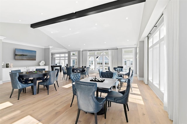 dining area with beam ceiling, high vaulted ceiling, and light wood-type flooring
