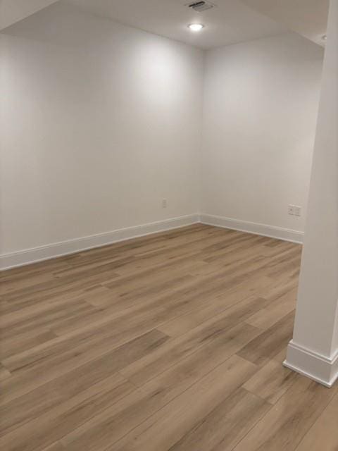 unfurnished room with light wood finished floors, baseboards, and recessed lighting
