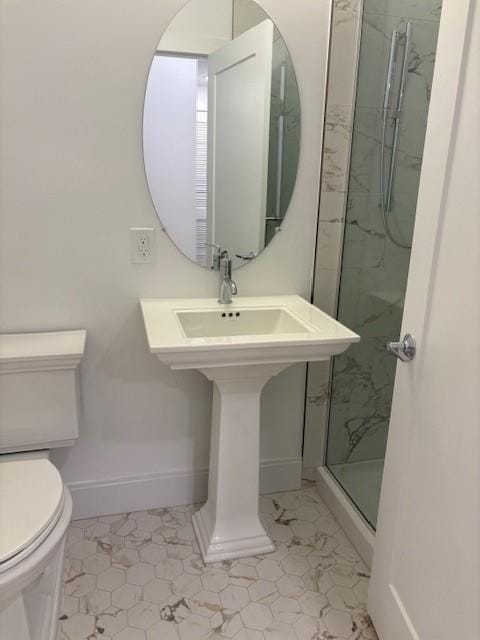 bathroom featuring a stall shower, toilet, baseboards, and tile patterned flooring