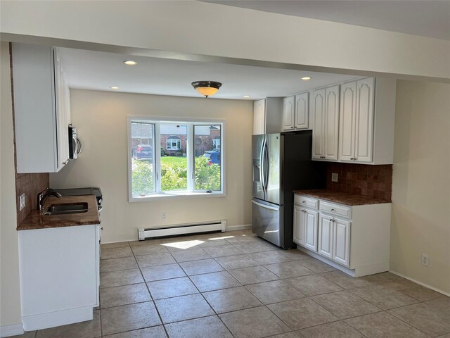 kitchen with a baseboard heating unit, a sink, backsplash, light tile patterned floors, and recessed lighting