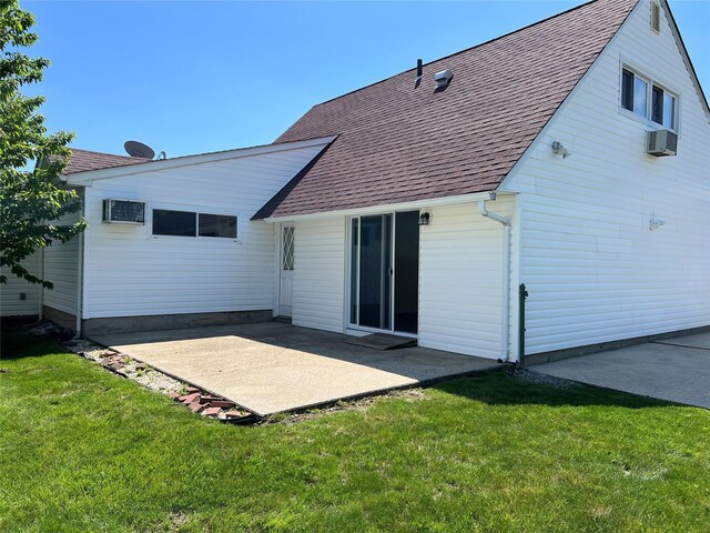 rear view of house with a patio area, a lawn, and roof with shingles