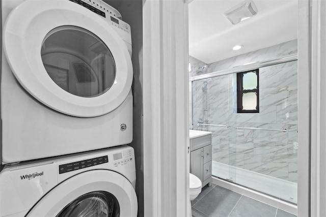 1271 California Rd Unit 1L, Eastchester, NY 10709 - washroom featuring stacked washer / dryer and tile patterned flooring