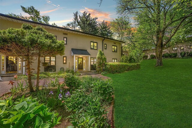 1271 California Rd Unit 1L, Eastchester, NY 10709 - back of property at dusk featuring a yard and stucco siding