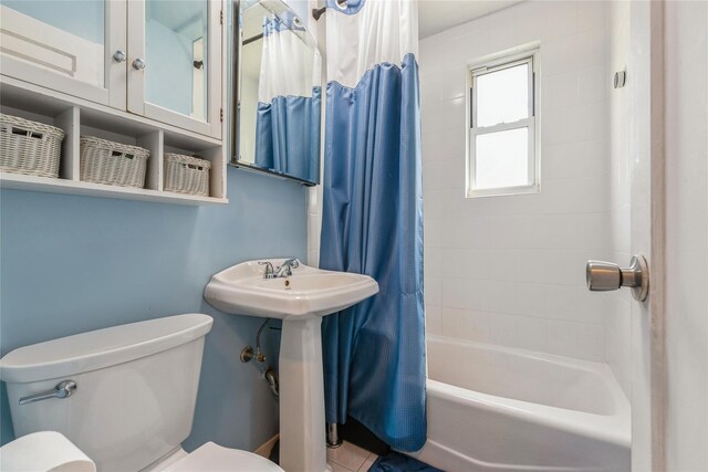 full bath featuring toilet and shower / tub combo with curtain