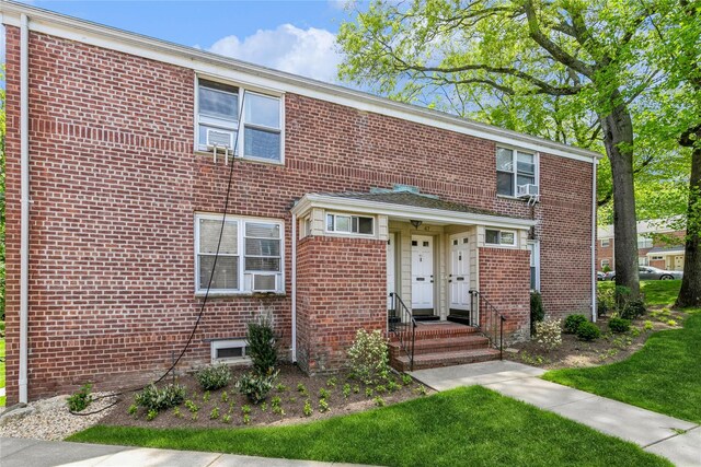 view of property with brick siding and cooling unit