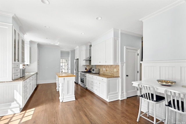 394 Mill Rd, Westhampton, NY 11977 - kitchen with stainless steel appliances, wooden counters, dark wood-style flooring, tasteful backsplash, and crown molding