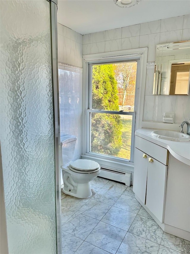 bathroom with baseboard heating, marble look tiles, plenty of natural light, and vanity