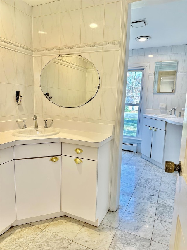 bathroom featuring marble finish floors, tile walls, a baseboard radiator, and vanity