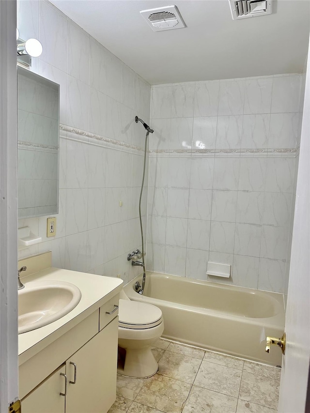 bathroom with tile walls,  shower combination, toilet, and vanity