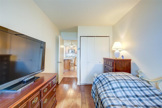 bedroom featuring a closet, hardwood / wood-style floors, and a textured ceiling