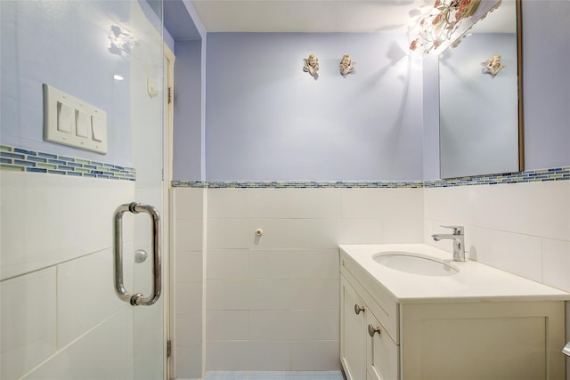 full bath with tile walls, vanity, and a stall shower