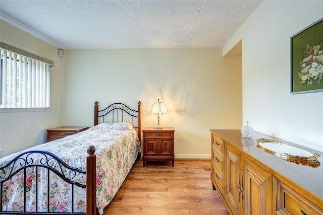 bedroom with light wood-style floors and a textured ceiling