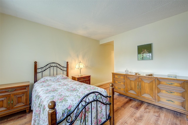 bedroom featuring light wood-style floors and baseboards