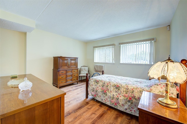 bedroom featuring wood finished floors and a textured ceiling