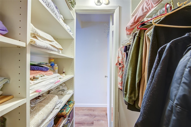 walk in closet with wood finished floors