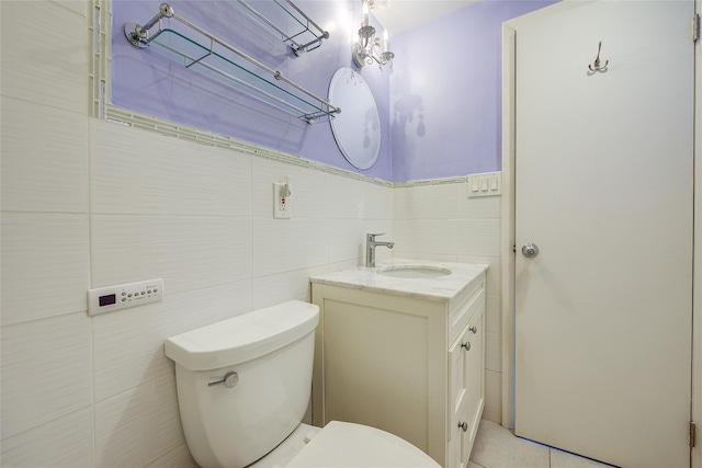 bathroom featuring tile walls, toilet, vanity, and tile patterned floors
