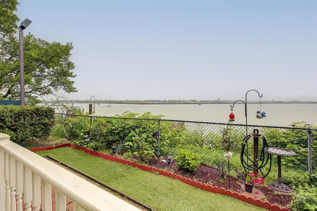 view of yard featuring a water view and fence