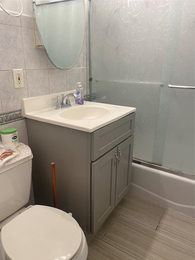 8410 101st St Unit 3U, Richmond Hill, NY 11418 - bathroom featuring vanity, toilet, tile walls, and enclosed tub / shower combo