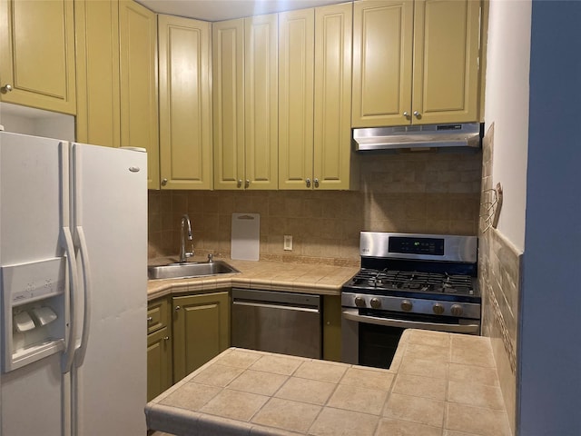 8410 101st St Unit 3U, Richmond Hill, NY 11418 - kitchen featuring appliances with stainless steel finishes, a sink, under cabinet range hood, tasteful backsplash, and cream cabinets