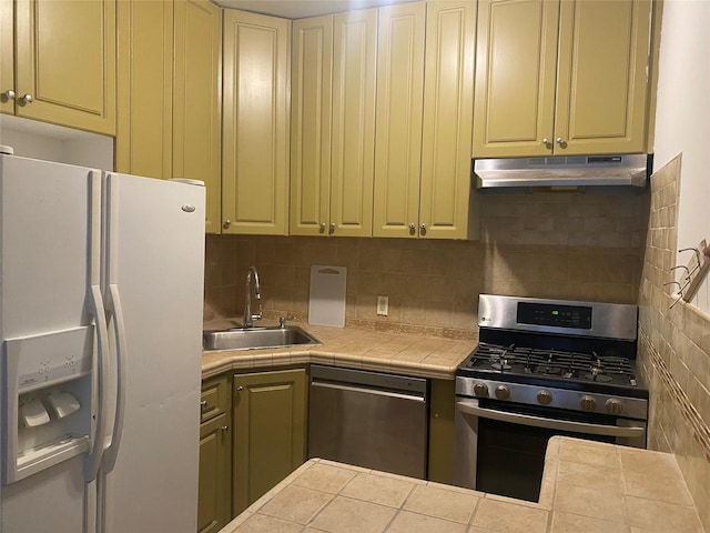 8410 101st St Unit 3U, Richmond Hill, NY 11418 - kitchen featuring appliances with stainless steel finishes, under cabinet range hood, tile counters, decorative backsplash, and a sink