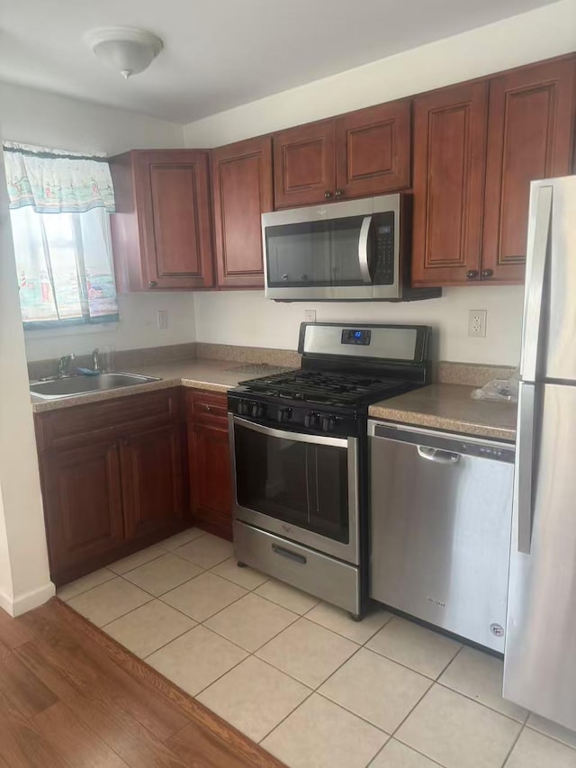 14A Mesereau Ct, Brooklyn, NY 11235 - kitchen with appliances with stainless steel finishes, a sink, and light tile patterned floors