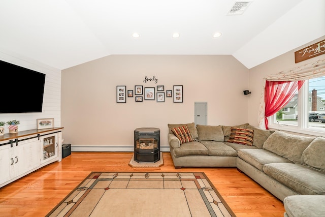 living room with vaulted ceiling, light wood-style flooring, baseboard heating, recessed lighting, and a wood stove