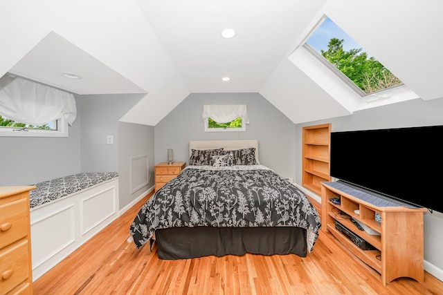 bedroom featuring wood finished floors, lofted ceiling, and a skylight
