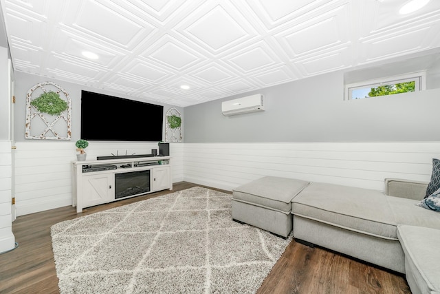living area featuring an ornate ceiling, a wall unit AC, wainscoting, dark wood-style flooring, and wood walls