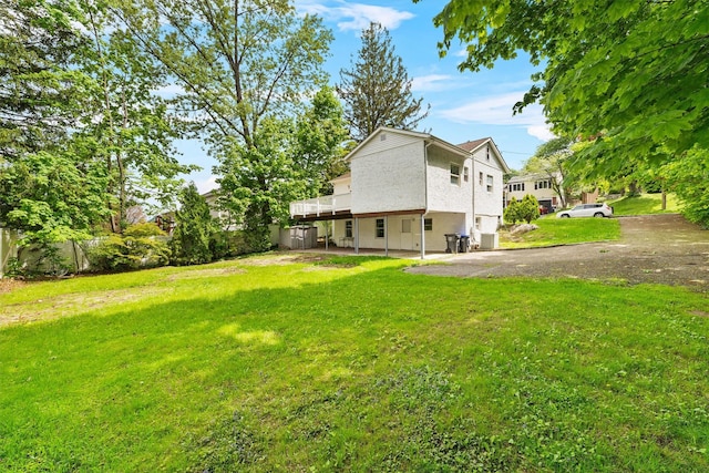 16 S Lawrence Ave, Elmsford, NY 10523 - back of property featuring driveway, a yard, a wooden deck, and stucco siding