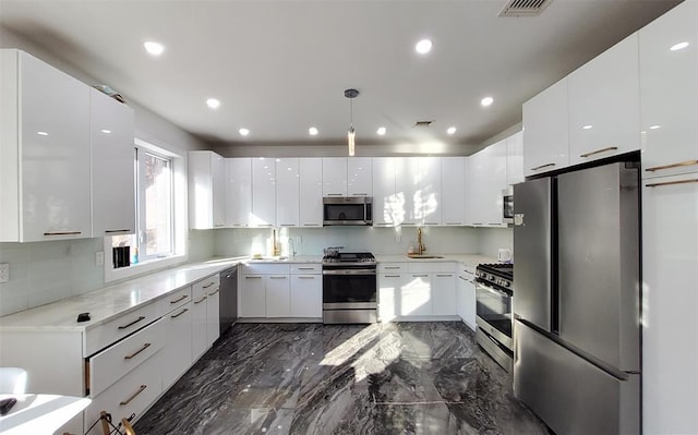 27 Catskill High Rail, Monroe, NY 10950 - kitchen with appliances with stainless steel finishes, modern cabinets, white cabinetry, a sink, and light countertops