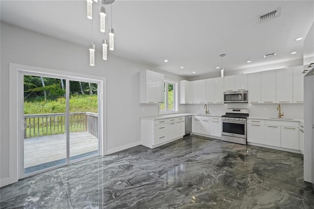 27 Catskill High Rail, Monroe, NY 10950 - kitchen with appliances with stainless steel finishes, dark marble finish flooring, baseboards, a sink, and light countertops
