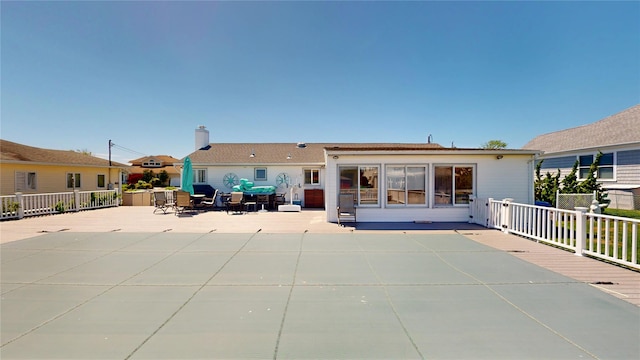 39 Whiting Rd, East Quogue, NY 11942 - rear view of house featuring a patio area and a chimney