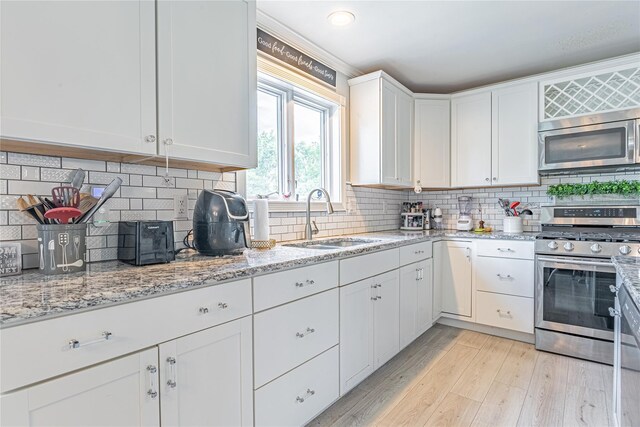 7 Angelas Way, Goshen, NY 10924 - kitchen featuring stainless steel appliances, a sink, white cabinetry, light wood finished floors, and tasteful backsplash