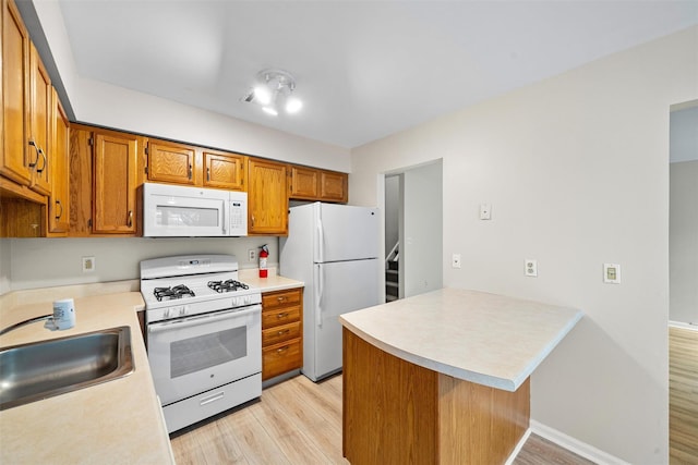 65 Jimal Dr, Middletown, NY 10940 - kitchen featuring white appliances, a sink, light wood-style floors, a peninsula, and light countertops