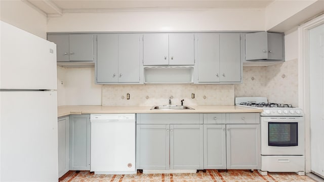 kitchen featuring white appliances, a sink, gray cabinetry, and backsplash