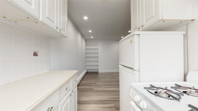 kitchen featuring recessed lighting, white cabinets, light countertops, light wood-style flooring, and tasteful backsplash