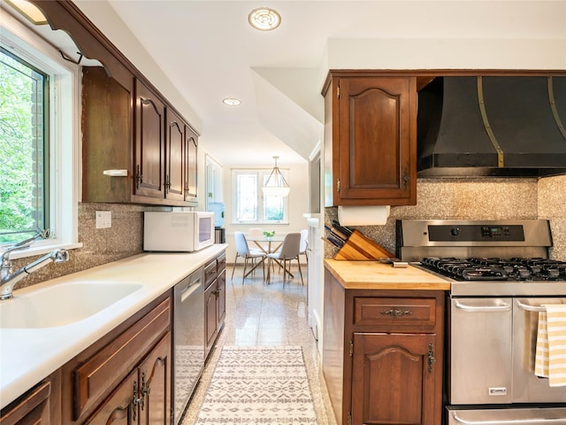 37 Longview Rd, Port Washington, NY 11050 - kitchen featuring stainless steel appliances, wall chimney exhaust hood, a sink, healthy amount of natural light, and recessed lighting