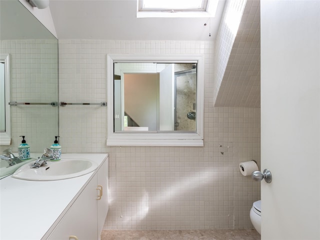 37 Longview Rd, Port Washington, NY 11050 - bathroom featuring tile walls, a skylight, toilet, vanity, and tile patterned flooring