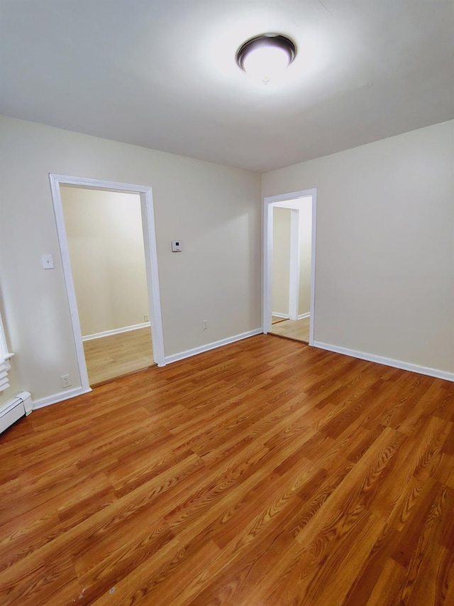 empty room with baseboards and light wood-style flooring