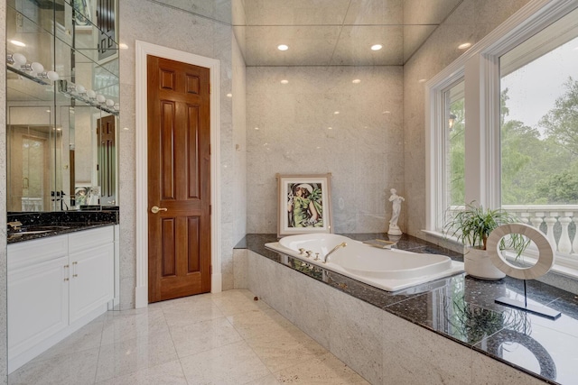 bathroom with vanity and a bath