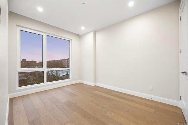 spare room featuring light wood-style flooring, baseboards, and recessed lighting